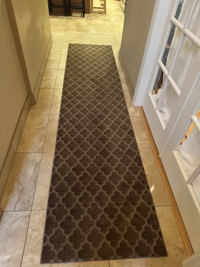 A brown trellis runner in a tiled hallway